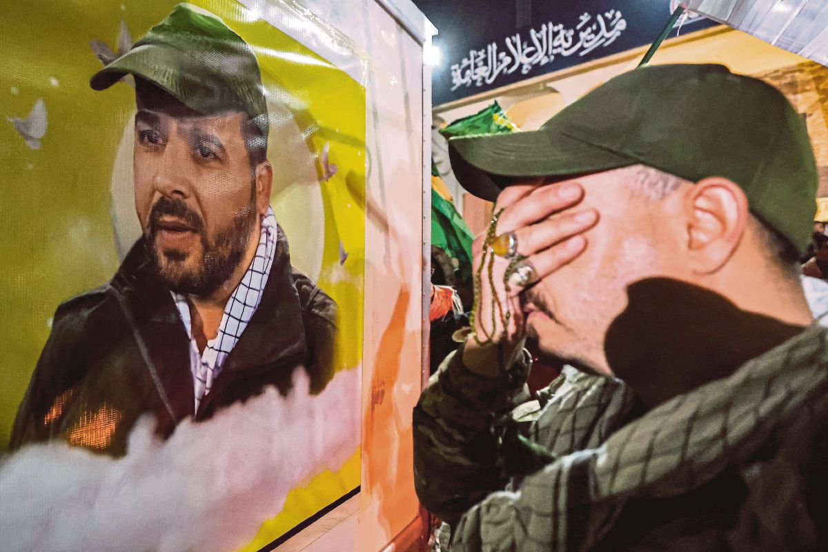 SEORANG individu menangis di tepi kenderaan membawa jenazah Mushtaq Jawad Kazim al Jawari. FOTO AFP