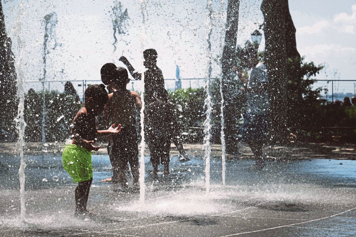 KANAK-KANAK bermain air pancut ketika cuaca panas di New York. FOTO Getty Images via AFP