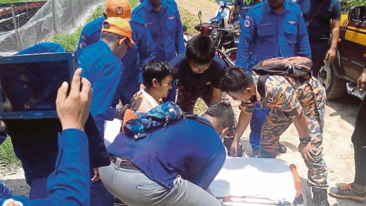 Mangsa (gambar kecil) diangkat anggota bomba dan penyelamat selepas basikalnya jatuh ke dalam gaung di Gunung Nuang, Hulu Langat. 