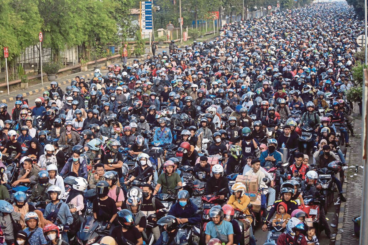 PENUNGGANG motosikal menunggu untuk menaiki feri di Banten, Pulau Jawa  untuk pulang berhari raya di Sumatera. FOTO AFP