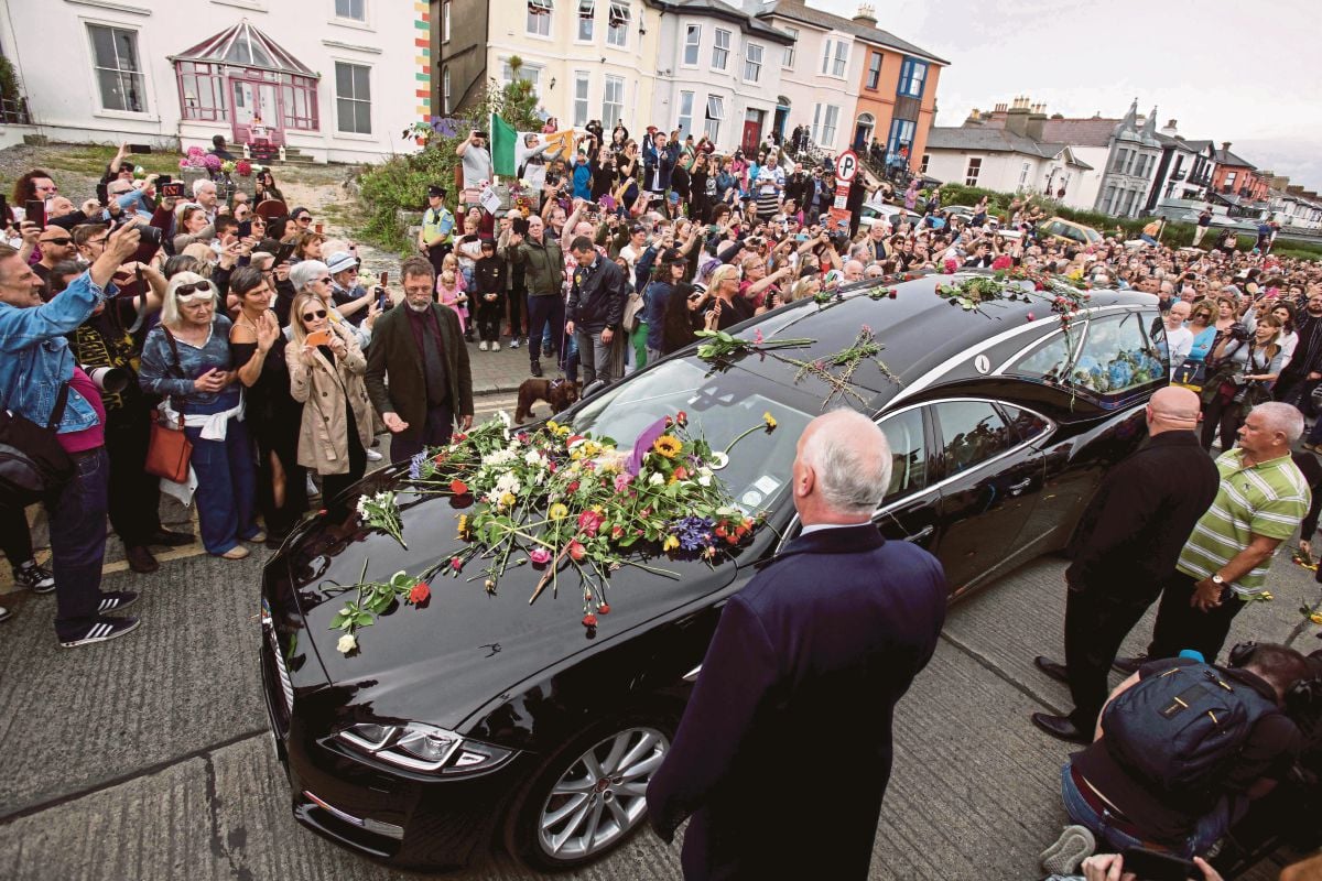 ORANG ramai meletakkan bunga di kenderaan yang membawa keranda Sinead O'Connor. FOTO AFP