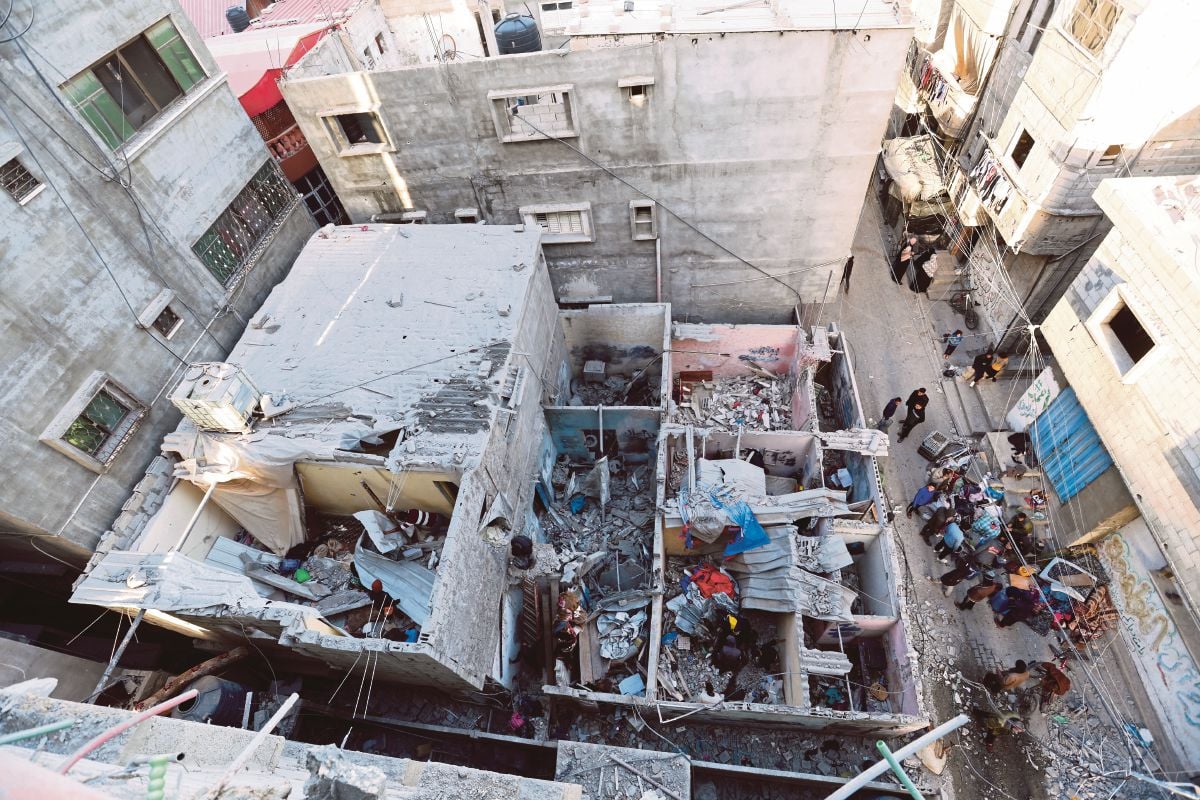 PENDUDUK Palestin berkumpul berhampiran bangunan yang rosak susulan serangan udara Israel. FOTO Reuters 