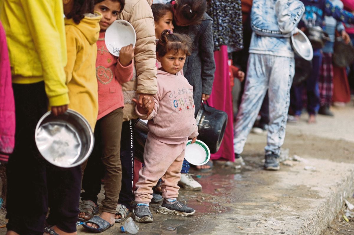 PENDUDUK Palestin menunggu untuk menerima bantuan makanan di Rafah. FOTO Reuters