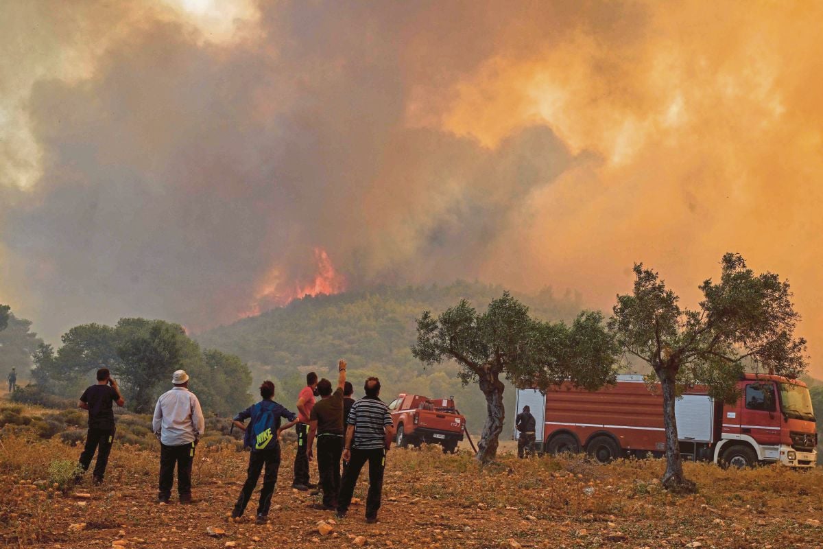 ORANG ramai melihat kebakaran hutan di New Peramos, dekat Athens, pada Julai 2023. FOTO AFP