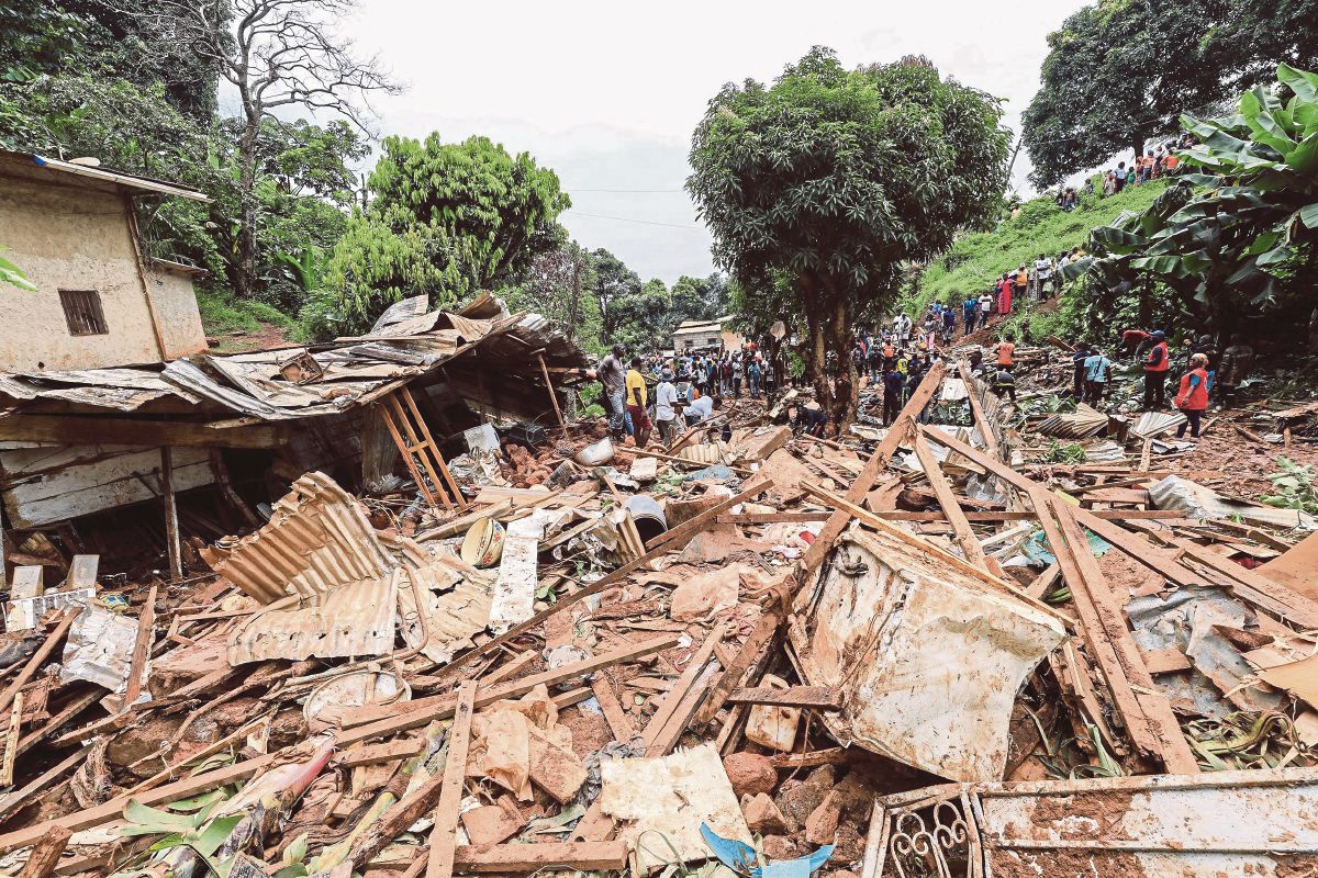 PENDUDUK melihat kesan kemusnahan disebabkan tanah runtuh di Mbankolo, barat laut Yaounde, pada 9 Oktober. FOTO AFP 