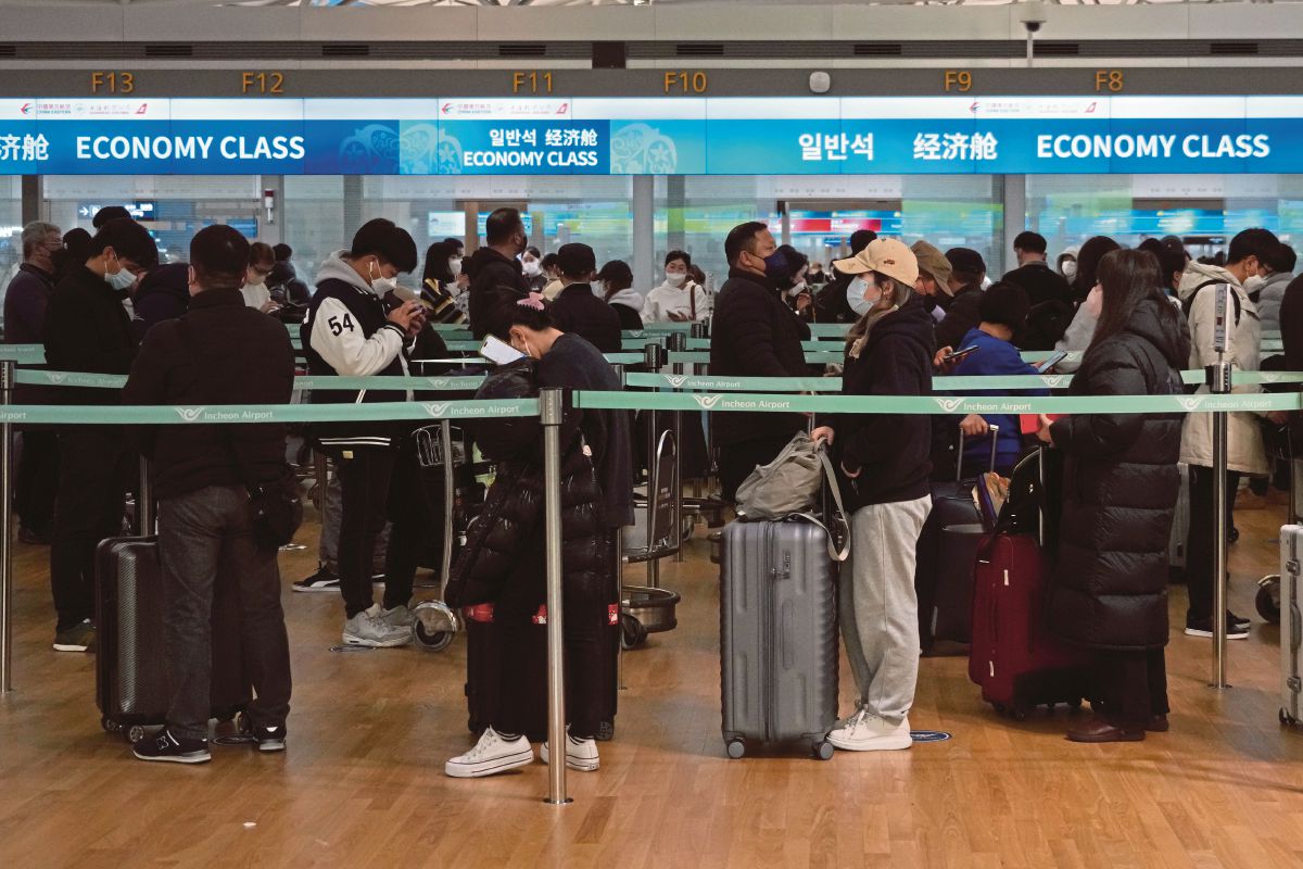 PENUMPANG beratur untuk memasuki pesawat ke China, di Lapangan Terbang Antarabangsa Incheon, Korea Selatan. FOTO AP 