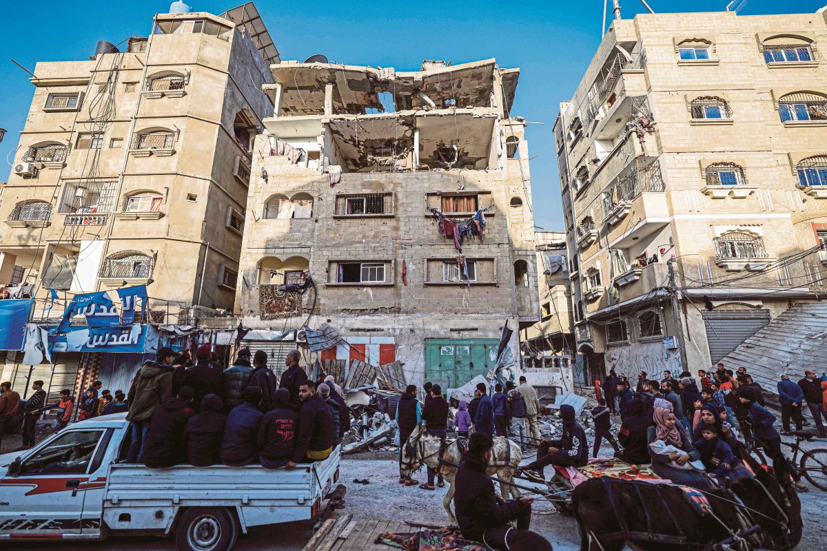 ORANG ramai melihat bangunan yang menjadi tempat tinggal seorang komander Hamas dan keluarganya, musnah susulan serangan Israel di Rafah, selatan Gaza. FOTO AFP