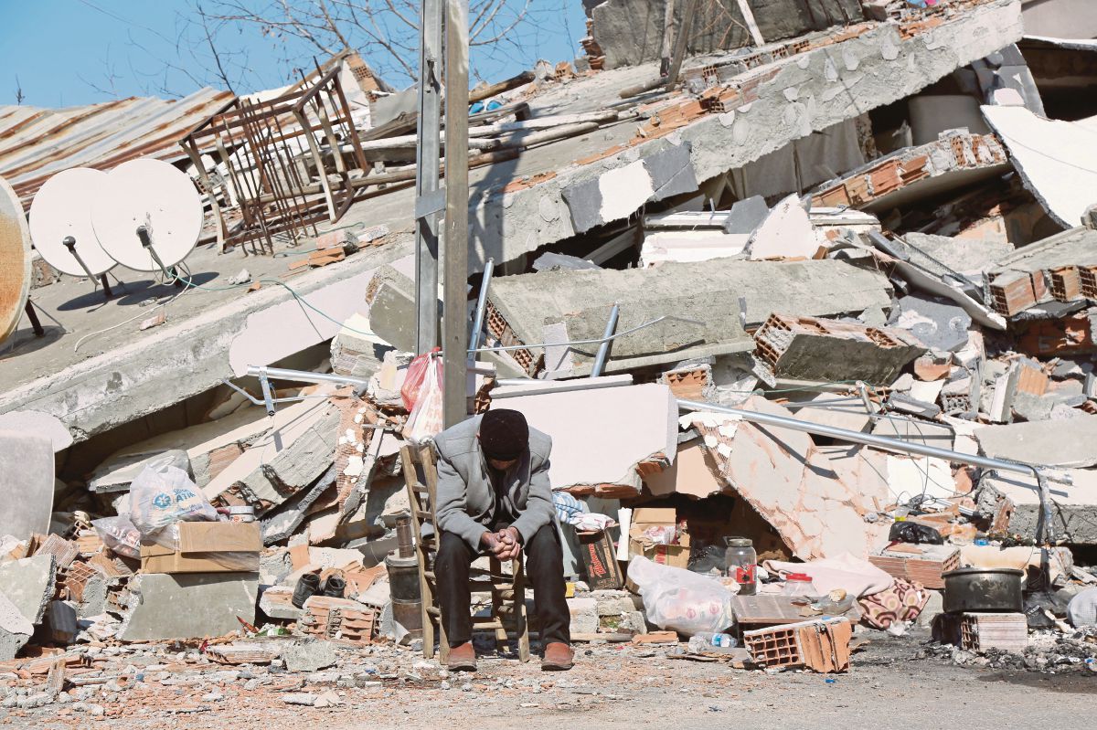 SEHO Uyan, yang kehilangan empat saudaranya duduk di kawasan runtuhan bangunan di Adiyaman, Turkiye. FOTO Reuters 