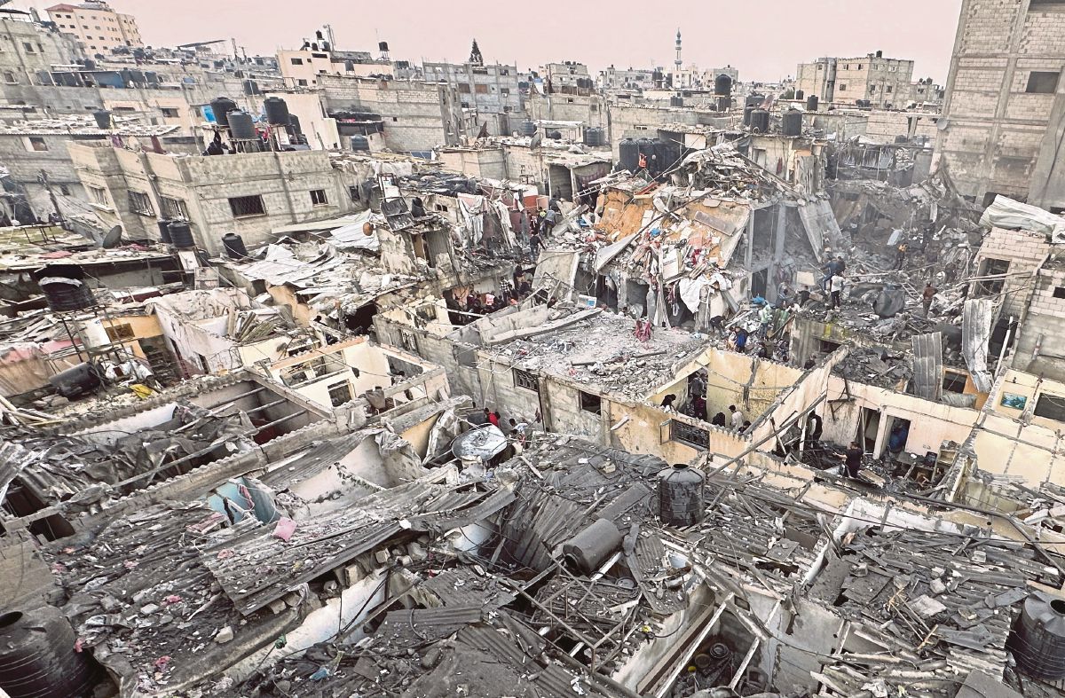 PENDUDUK melakukan pencarian di kawasan bangunan runtuh di Rafah, selatan Gaza. FOTO Reuters