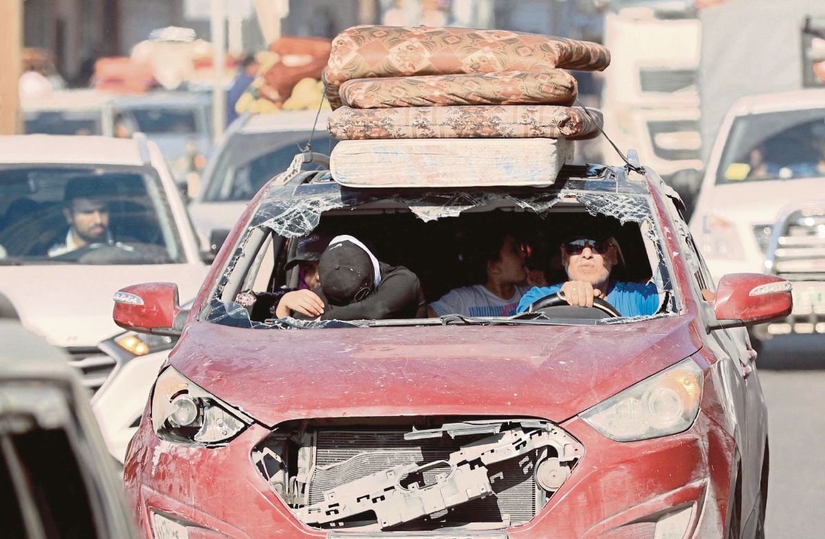 PENDUDUK Gaza menaiki kereta yang mengalami kerosakan dalam usaha melarikan diri ke Semenanjung Gaza. FOTO AFP