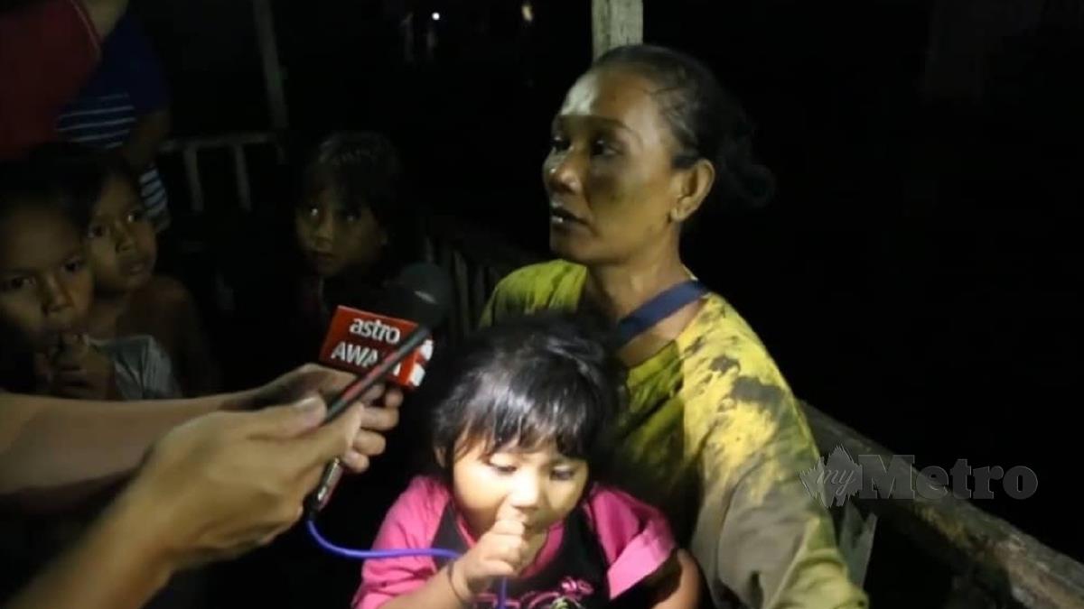 SAHARA bersama tujuh anaknya ketika ditemui di lokasi kebakaran di Kampung Dumpil, Putatan. FOTO Juwan Riduan