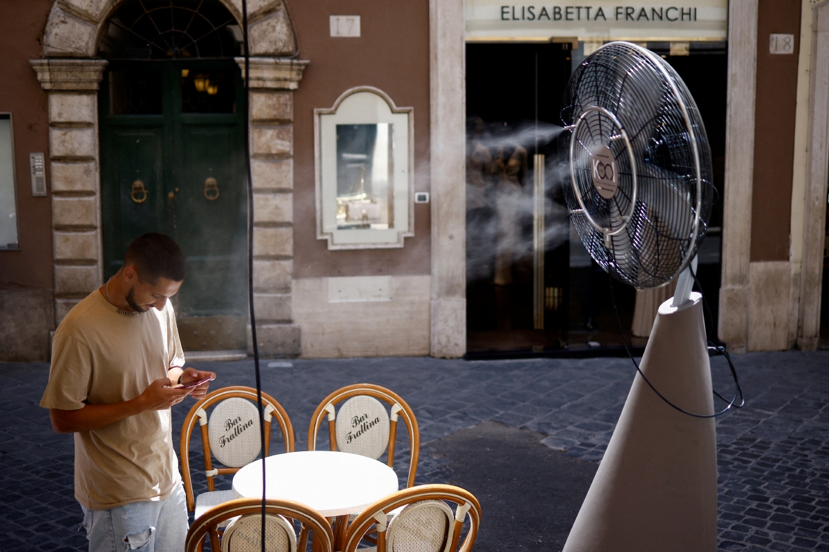 LELAKI berdiri berhampiran kipas ketika cuaca panas di Rom, pada Jumaat lalu. FOTO Reuters 