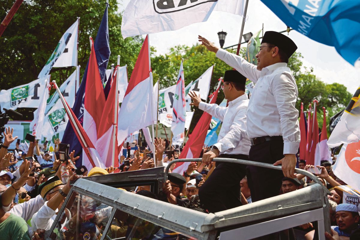 CALON Presiden dan Naib Presiden Indonesia, Anies Baswedan (tengah, kiri) dan Muhaimin Iskandar (tengah, kanan) melambai kepada penyokong di depan Suruhanjaya Pilihan Raya di Jakarta. FOTO AFP