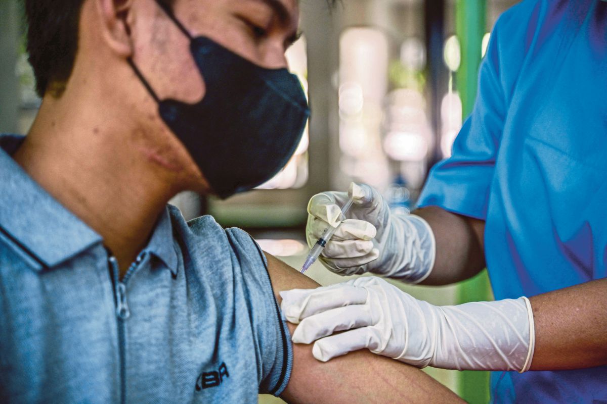 PETUGAS kesihatan menyuntik vaksin Covid-19 kepada seorang lelaki di sebuah pejabat kesihatan dii Jakarta. FOTO AFP 