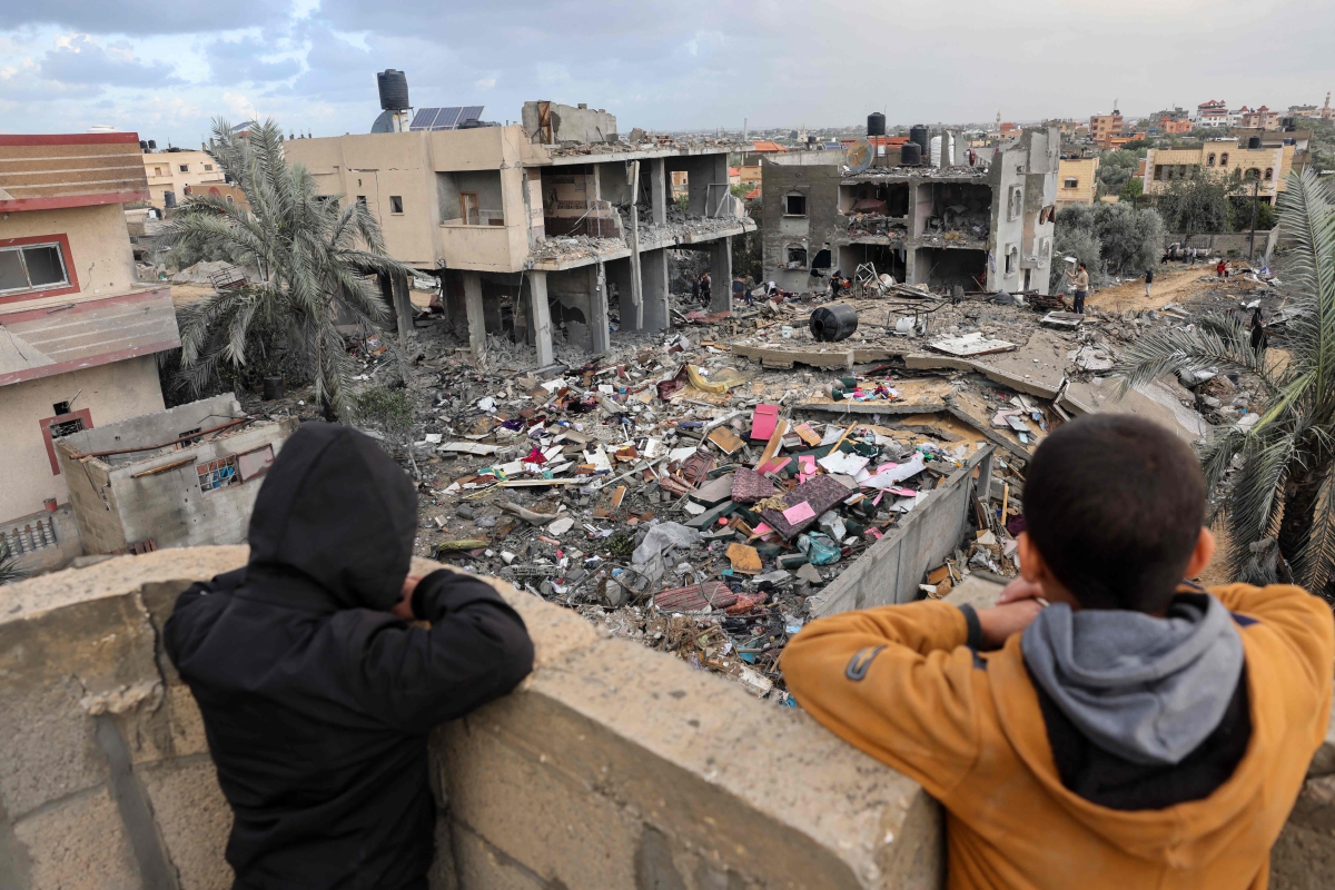 KANAK-KANAK Palestin melihat bangunan yang runtuh susulan serangan udara Israel di Rafah, selatan Gaza. FOTO AFP 