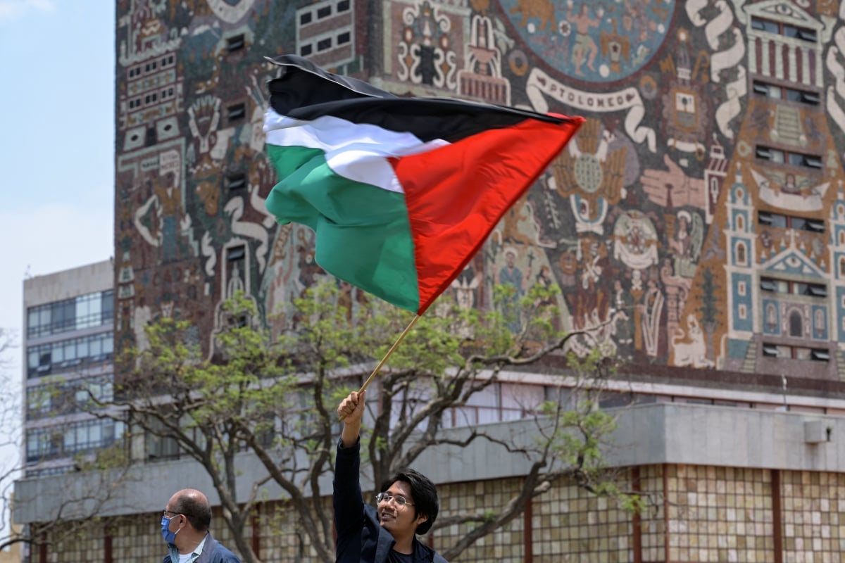 AKTIVIS pro-Palestin mengibarkan bendera Palestin di sebuah kampus universiti di Mexico. FOTO AFP