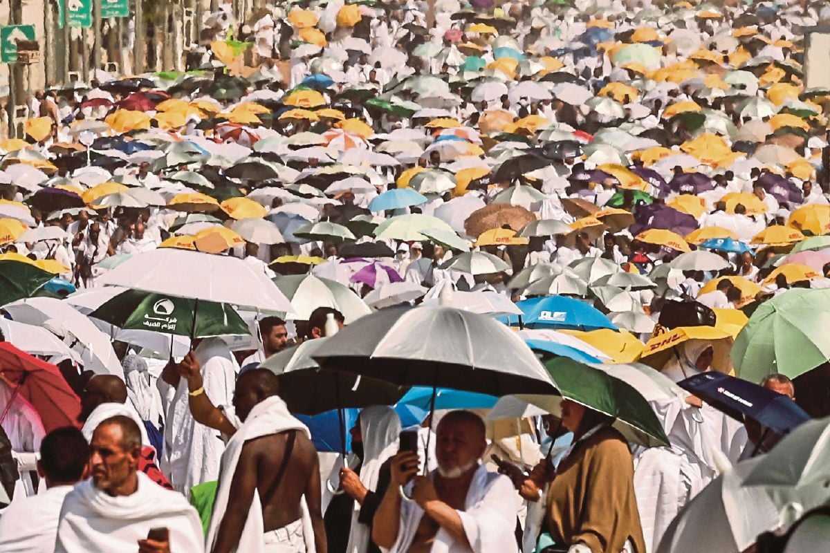 FOTO pada 15 Jun lalu menunjukkan jemaah haji menggunakan payung ketika tiba di Gunung Arafah. FOTO AFP 