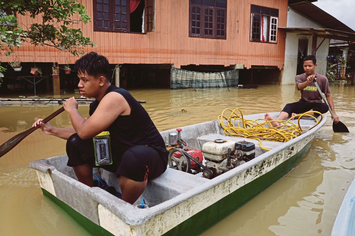 SEGELINTIR mangsa banjir mula kembali ke rumah masing-masing selepas paras air mulai surut di Kampung Durian Mentangau,  Dungun, semalam. FOTO Bernama