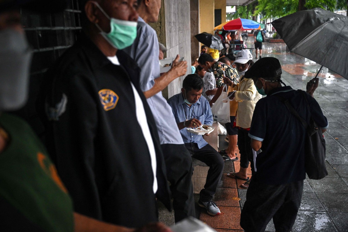 Sebahagian orang awam yang mendapatkan makanan percuma yang dikendalikan Yayasan Bantuan Komuniti Bangkok. - FOTO AFP