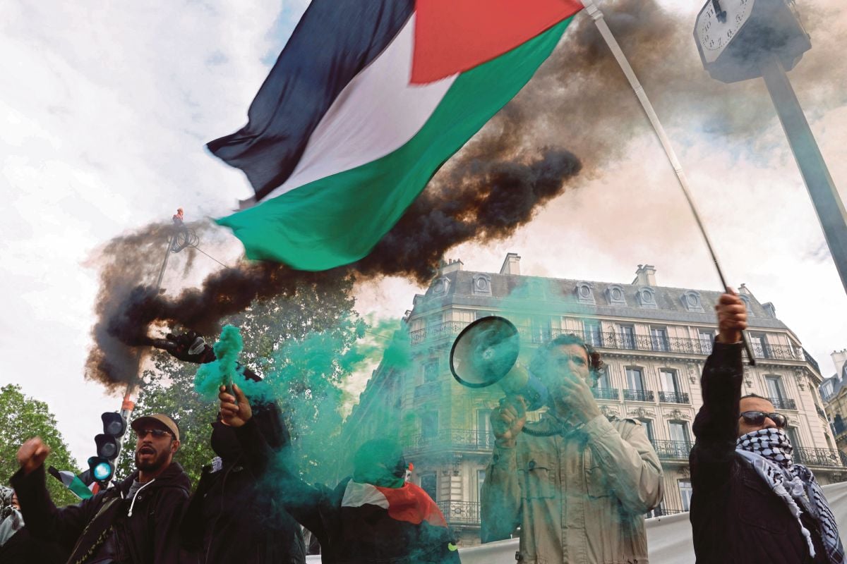 PENUNJUK perasan mengibarkan bendera Palestin ketika demonstrasi di Paris, Isnin lalu. FOTO AFP