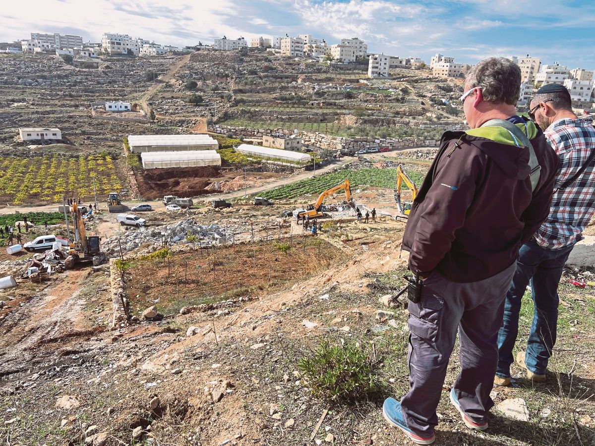 PEKERJA Israel memerhatikan jenteranya merobohkan rumah penduduk Palestin di Hebron, Tebing Barat. FOTO Reuters 