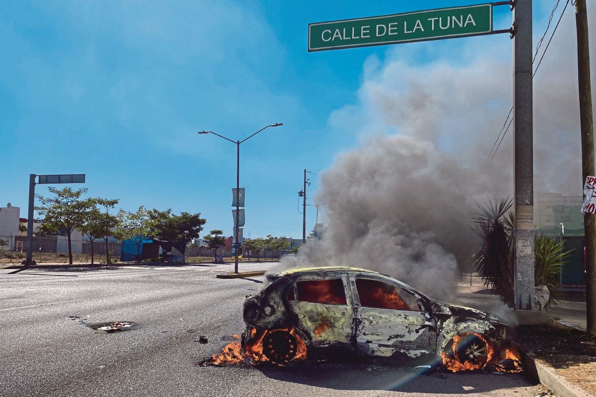 KERETA terbakar di jalan raya ketika operasi bagi menangkap Ovidio Guzman di Culiacan, negeri Sinaloa, Mexico. FOTO AFP 