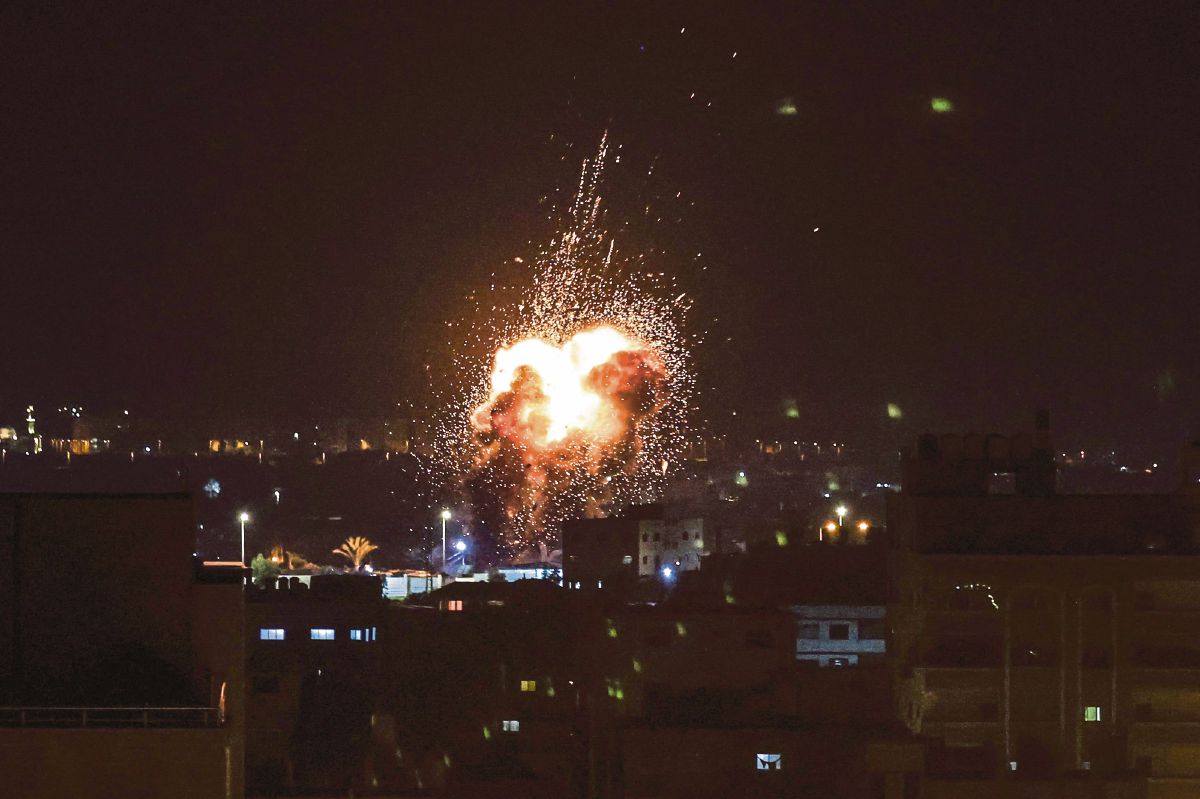 API dan asap kelihatan di atas bangunan di Gaza selepas Israel melancarkan serangan di wilayah Palestin itu. FOTO AFP 