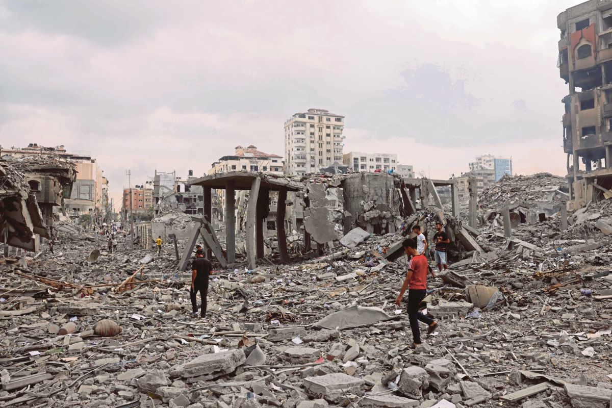 PENDUDUK Gaza memeriksa kesan kemusnahan susulan serangan udara Israel. FOTO AFP 