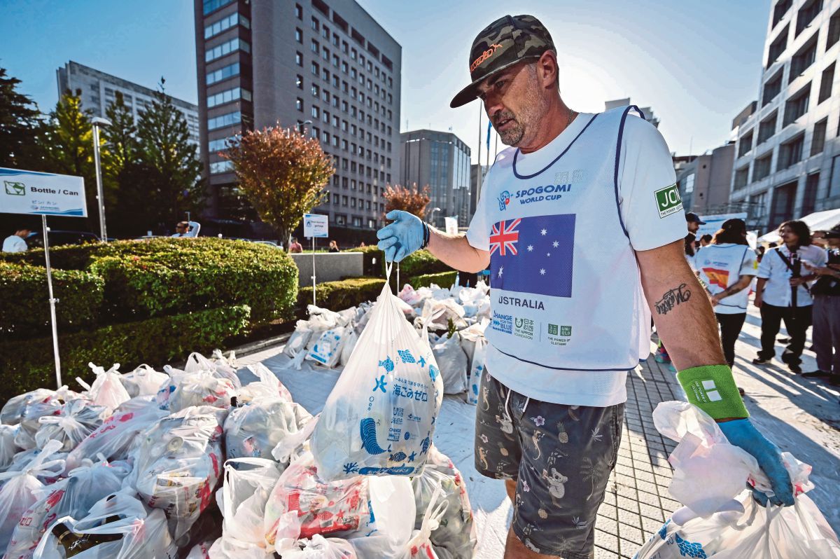 PESERTA dari Australia membawa beg berisi sampah. FOTO AFP 