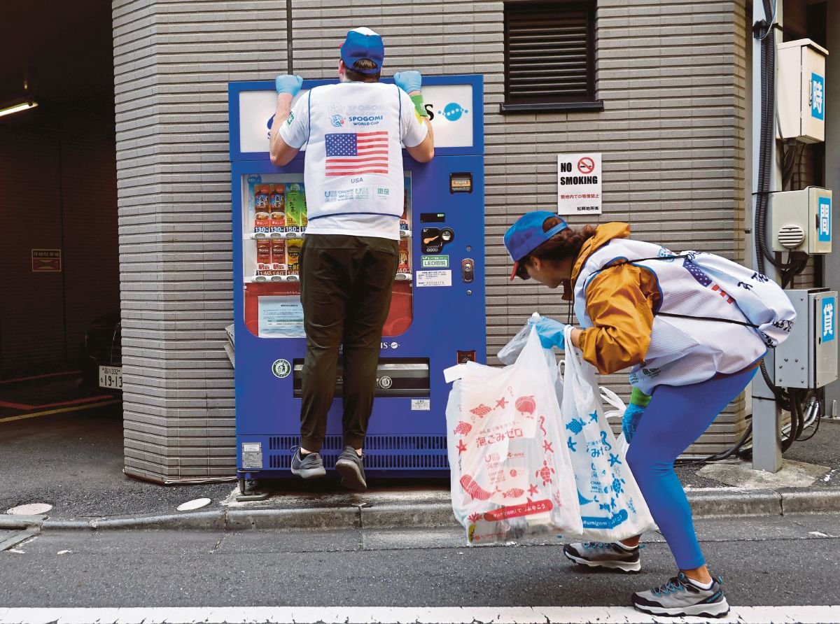 PESERTA dari Amerika Syarikat mencari sampah di mesin layan diri ketika menyertai Piala Dunia Spogomi di Jepun. FOTO Reuters