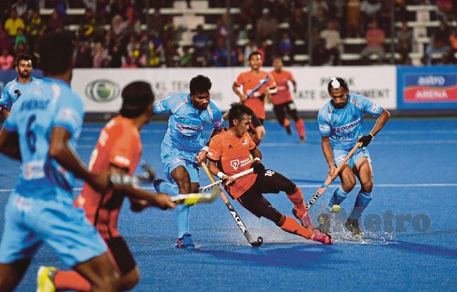 Pemain Malaysia, Faiz Jali (tengah) cuba melepasi halangan pemain India dalam saingan Hoki Piala Sultan Azlan Shah. FOTO Effendy Rashid.
