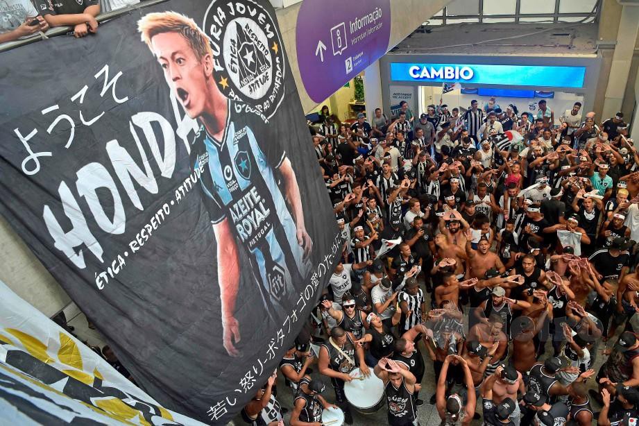 Peminat kelab bola sepak, Botafogo meraikan ketibaan Honda. FOTO AFP