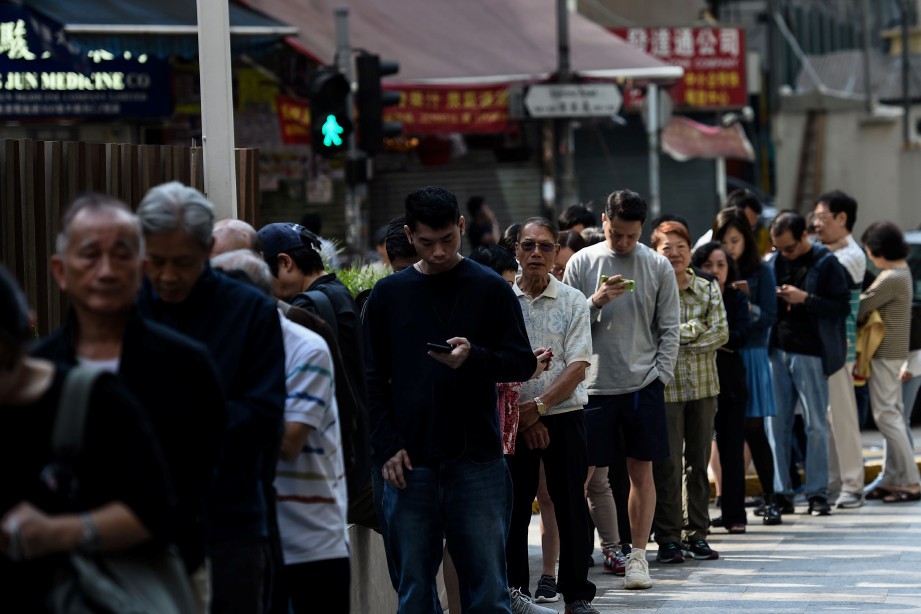 ORANG ramai beratur untuk membuang undi pilihan raya majlis daerah hari. FOTO AFP