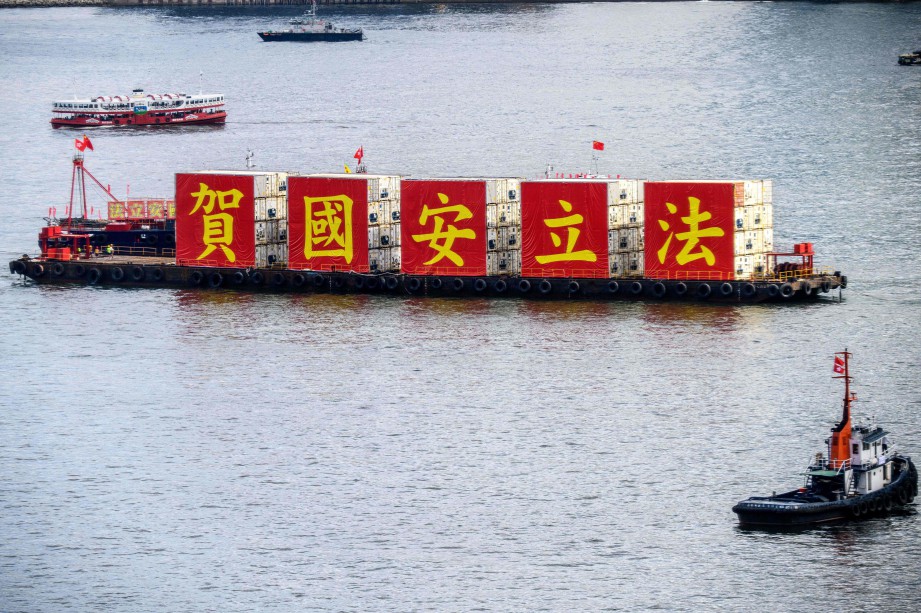 TONGKANG membawa kain rentang menyokong Akta Keselamatan Negara di Victoria Harbour, Hong Kong.  FOTO AFP 