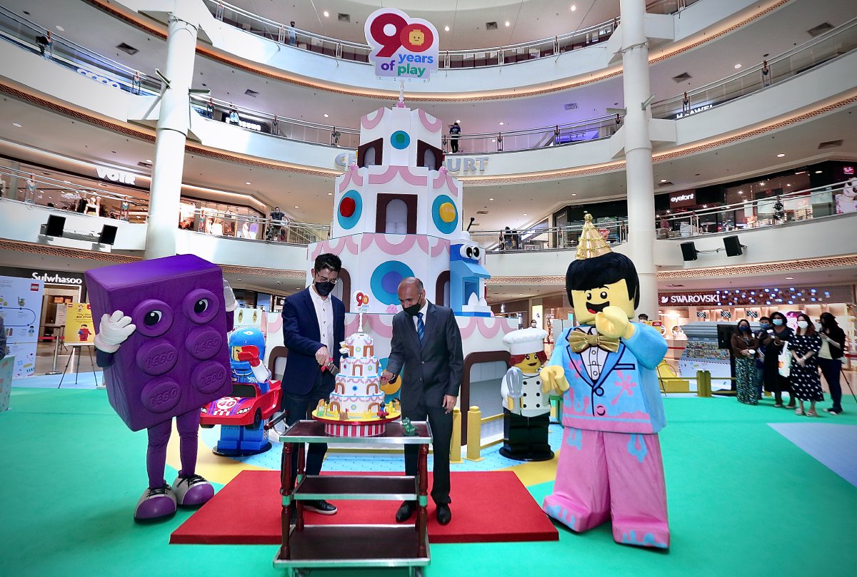 ROHAN bersama wakil Mid Valley Megamall dengan replika kek yang menjadi gimik pelancaran ulang tahun ke 90 LEGO. 