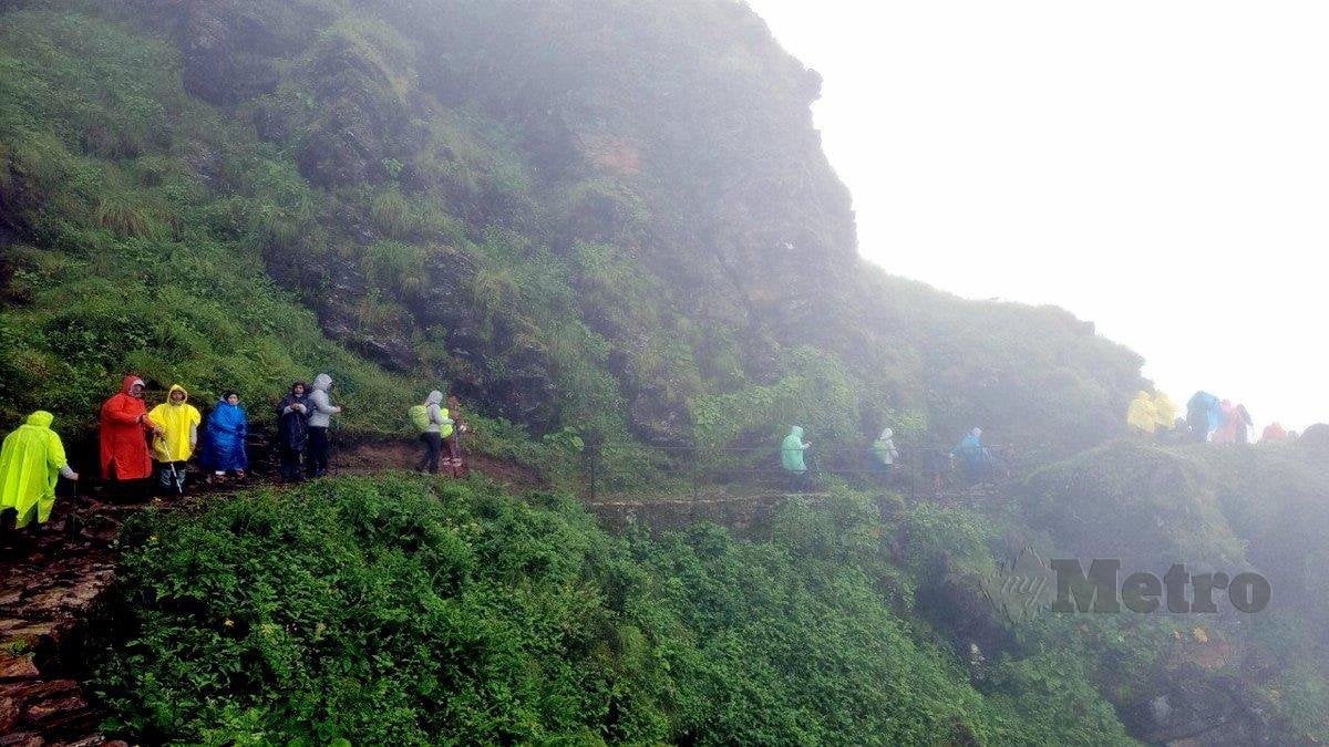 PENDAKI berjalan rapat ketika melalui lereng gunung yang curam.
