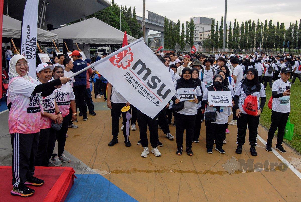 DR Junainah mengibarkan bendera MSU sebagai tanda pelepasan Program MSU Heritage Walk Series: Kajang. 