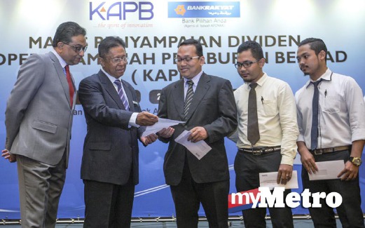 Ilyas (kiri) dan Pengerusi Bank Rakyat, Tan Sri Abdul Aziz Zainal (dua kiri) beramah mesra dengan penerima dividen Riza Makhzan Arifin (tengah) ketika Majlis Penyampaian Dividen. FOTO Hafiz Sohaimi