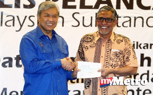AHMAD Zahid menyampaikan cek RM2 juta kepada Presiden MASAC, Datuk Yunus Pathi. FOTO Yazit Razali