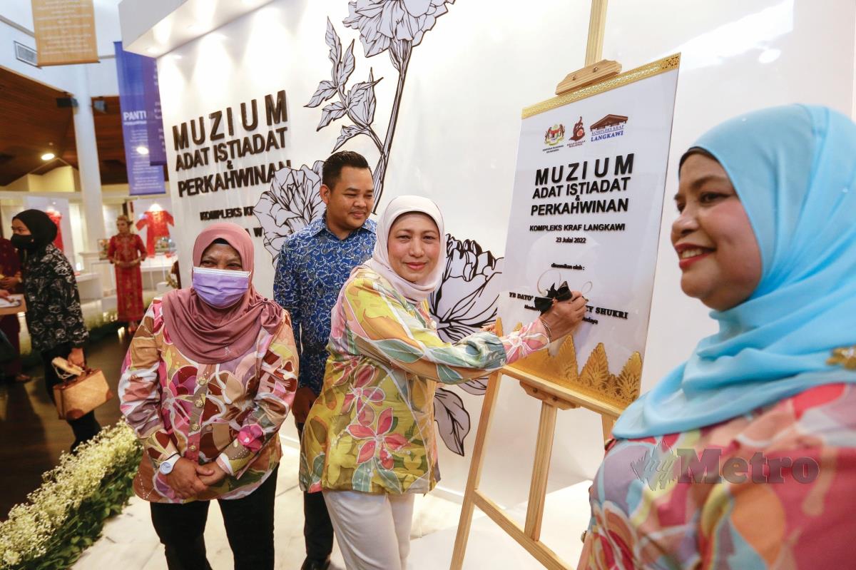 NANCY menurunkan tandatangan pada plak perasmian Muzium Adat Istiadat & Perkahwinan di Kompleks Kraf Langkawi.