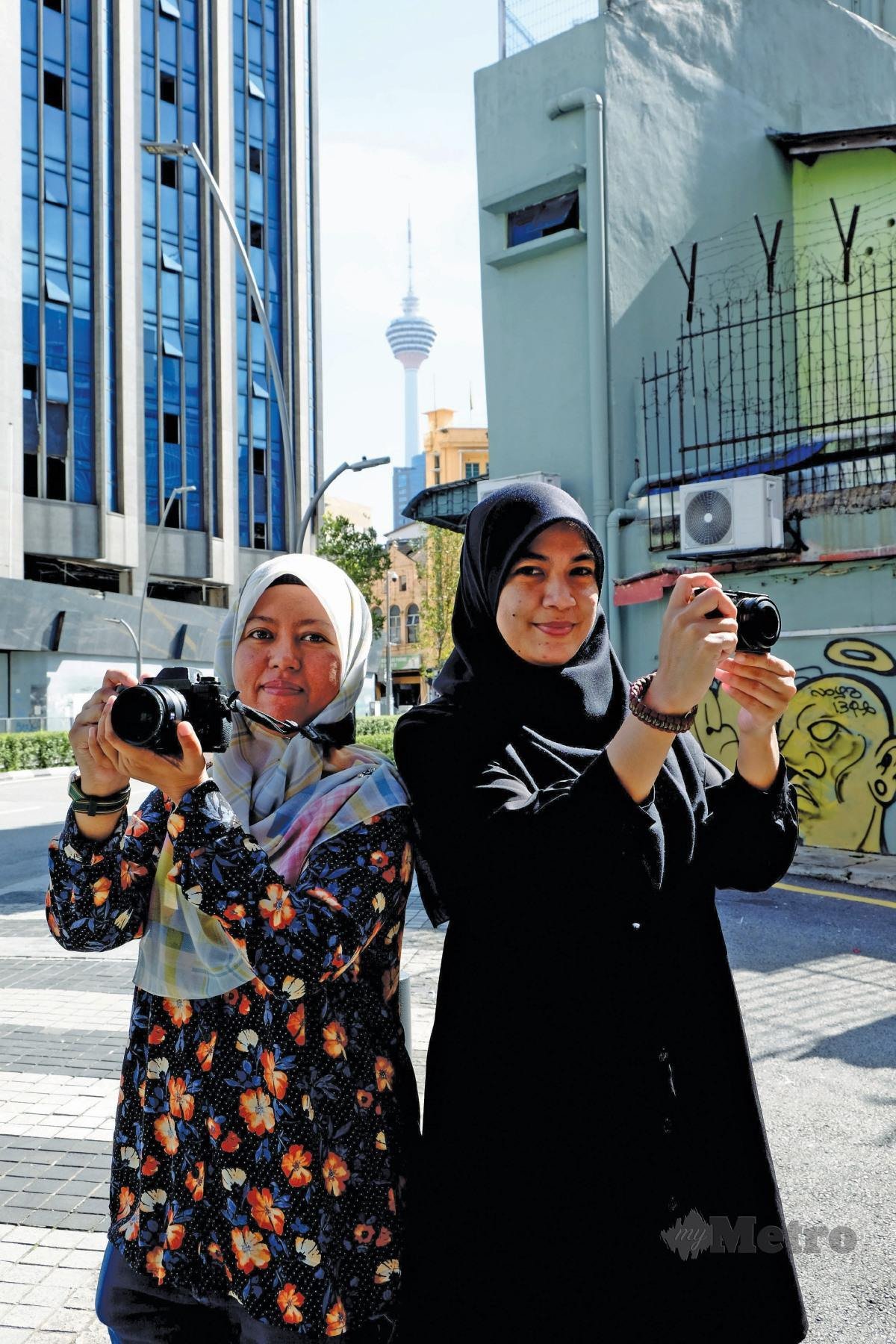 DUA sahabat yang memiliki hobi fotografi jalanan, Zalifah (kiri) dan Nazaehah ketika ditemui selepas temu bual di ibu kota.