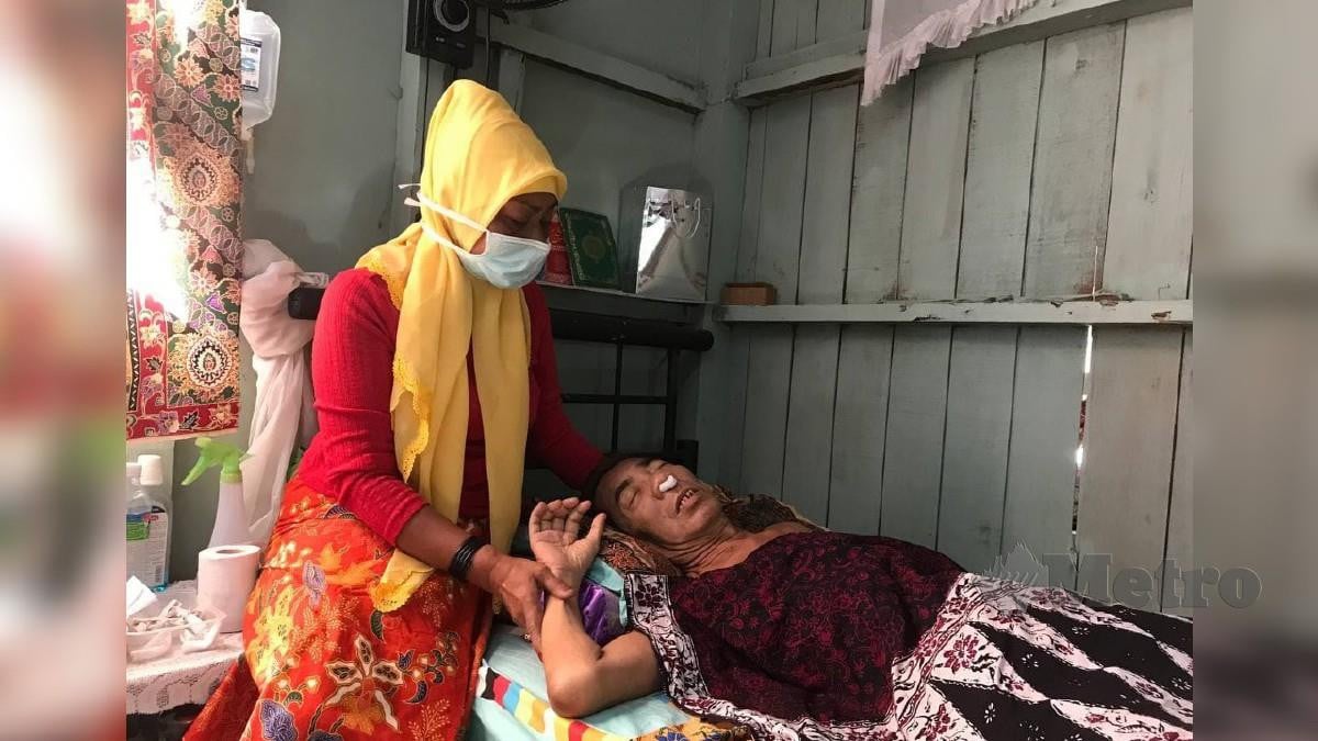 MAKALSOM menjaga serta menguruskan Wan Azman yang menghidap kanser pangkal hidung tahap empat ketika ditemui di Kampung Kuala Besar. FOTO Hazira Ahmad Zaidi