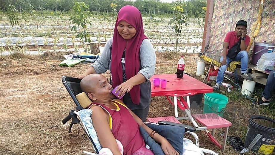 NOOR Aklima memberi air minuman kepada suaminya, Mohd Zuri. FOTO Siti Rohana Idris