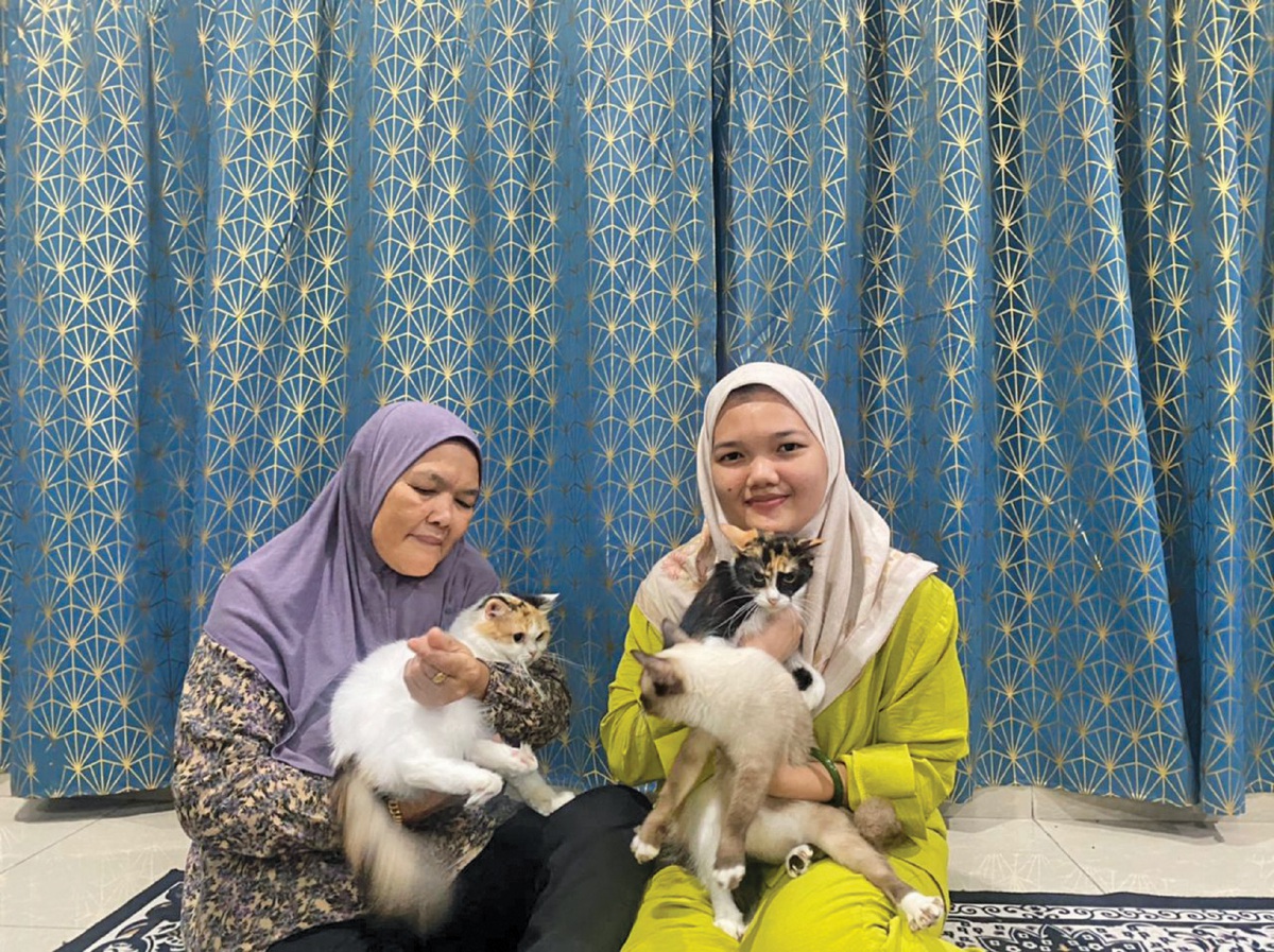 FATIHAH (kanan) dan ibunya menjaga kucing perliharaan mereka seperti ahli keluarga sendiri.