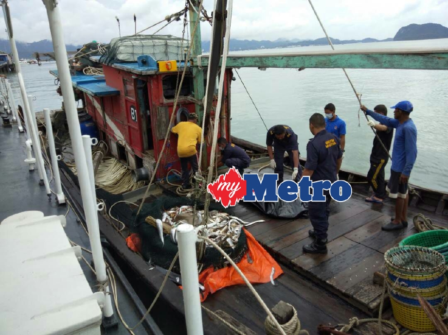 Anggota APMM memeriksa mayat nelayan yang tersangkut di pukat - FOTO ihsan APMM