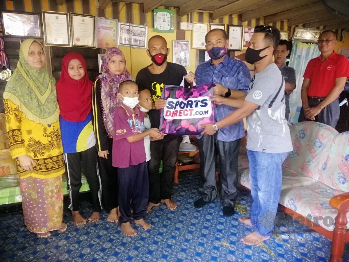 Adun Alor Pongsu, Datuk Sham Mat Sahat menyampaikan bantuan kepada keluarga Mahadi Mohd. FOTO SHAIFUL SHAHRIN AHMAD PAUZI
