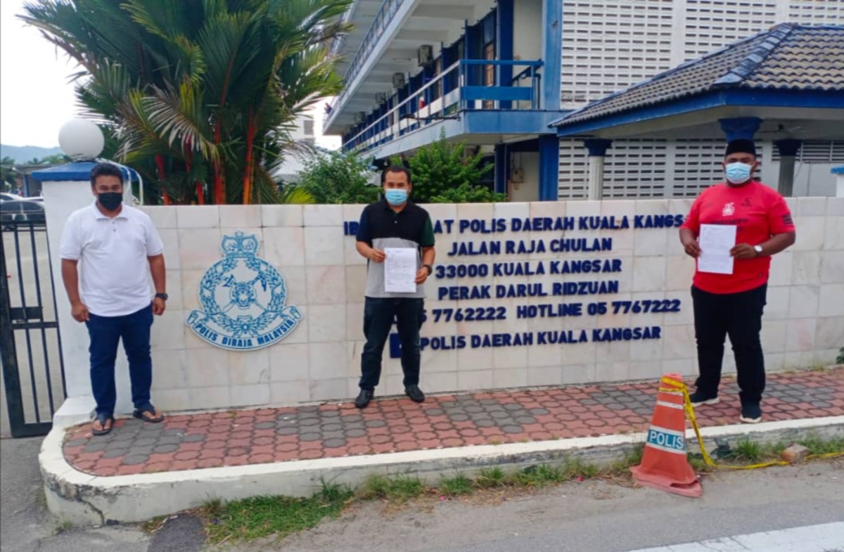 Mohd Ariff (tengah) menunjukkan laporan polis yang dibuat susulan poster dimuat naik pengguna media sosial Fahmi Reza. FOTO Ihsan Pemuda Umno Perak.