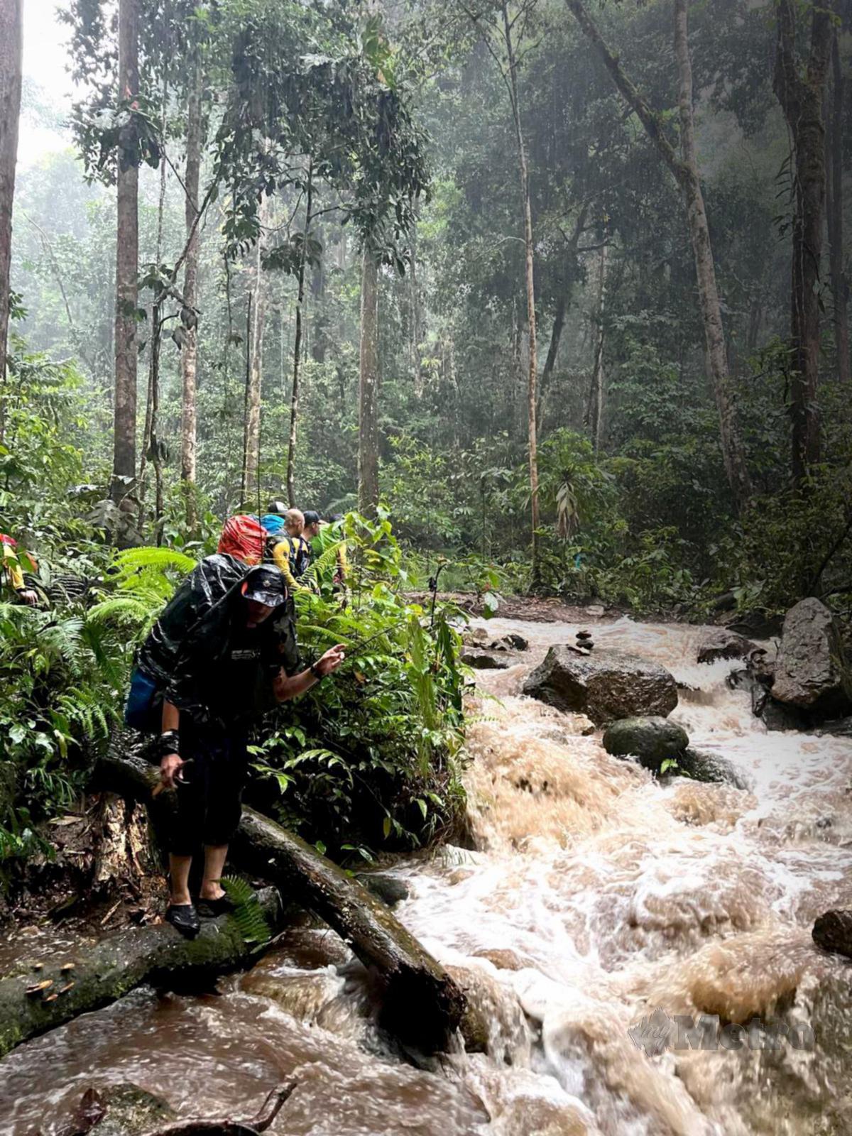 AIR sungai yang naik akibat hujan lebat menjadi cabaran untuk meneruskan aktiviti pendakian.