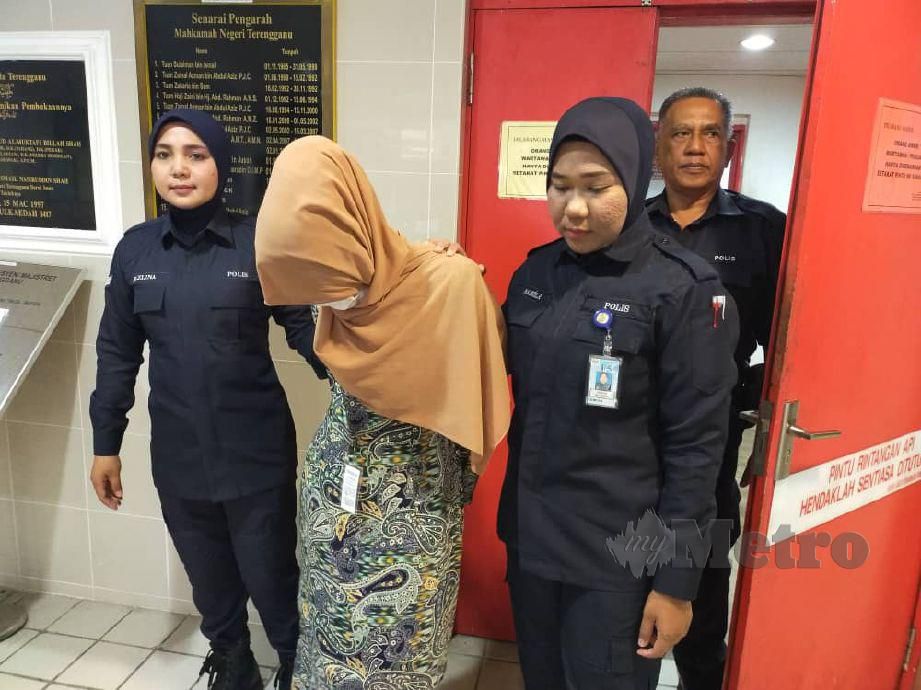 TERTUDUH diiringi polis selepas dijatuhi hukuman denda RM5,000. FOTO Zatul Iffah Zolkiply.