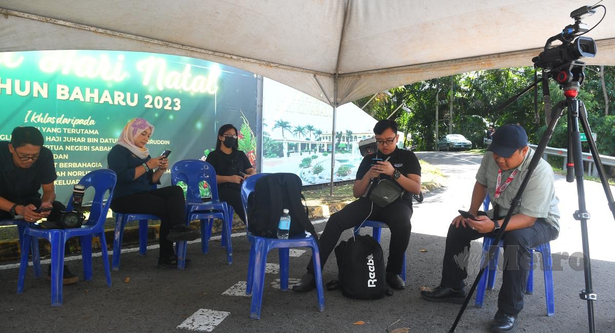  Petugas media yang membuat liputan berteduh di khemah yang disediakan di luar pintu masuk Istana Seri Kinabalu pagi ini susulan pergolakan politik di Sabah. FOTO MOHD ADAM ARININ